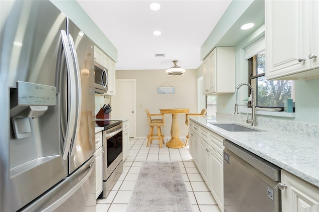 kitchen with white cabinetry, appliances with stainless steel finishes, a sink, and light tile patterned flooring