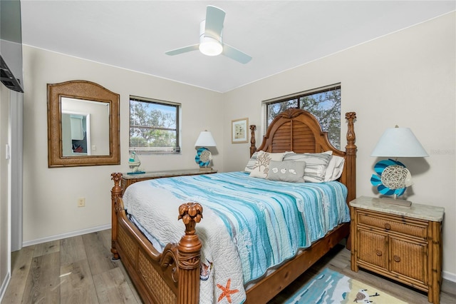 bedroom with a ceiling fan, light wood-type flooring, and baseboards