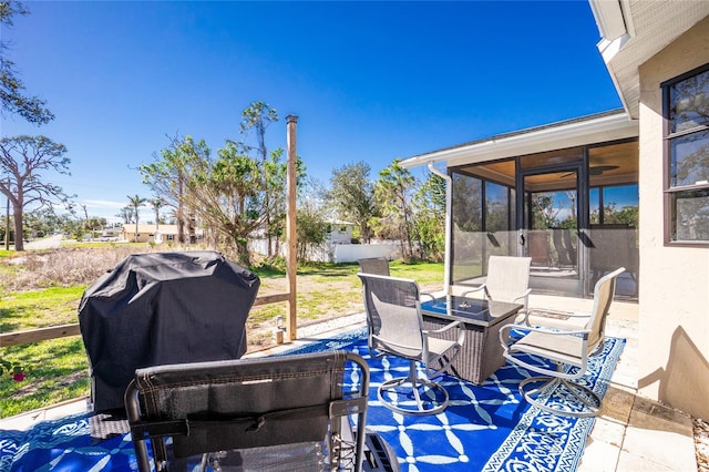 view of patio / terrace with a sunroom, a grill, and fence