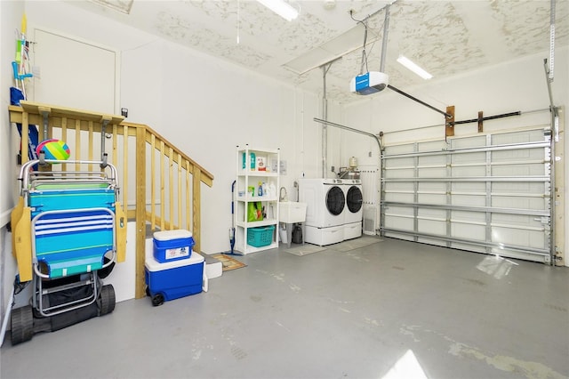 garage with a garage door opener, washing machine and dryer, and a sink