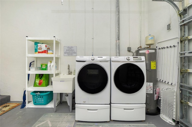 clothes washing area featuring water heater, laundry area, and independent washer and dryer