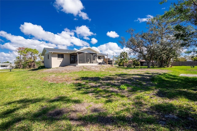 back of property with a lawn and a sunroom