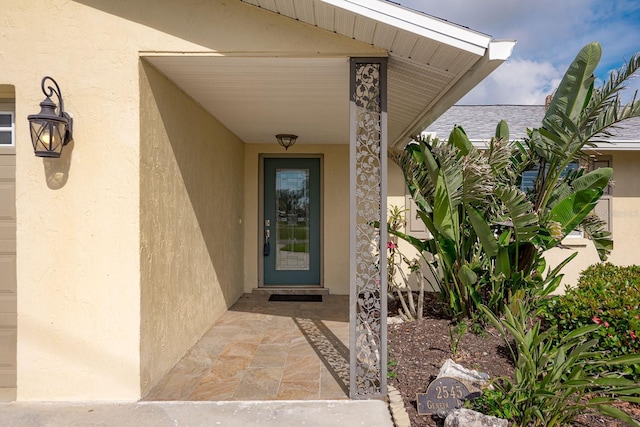 doorway to property with a water view and stucco siding