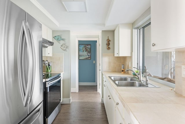 kitchen with white cabinets, decorative backsplash, tile countertops, stainless steel appliances, and a sink