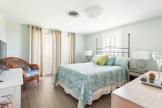 bedroom featuring visible vents and wood finished floors