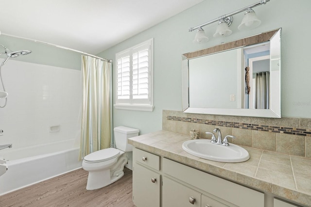 bathroom featuring tasteful backsplash, toilet, shower / bath combo, vanity, and wood finished floors