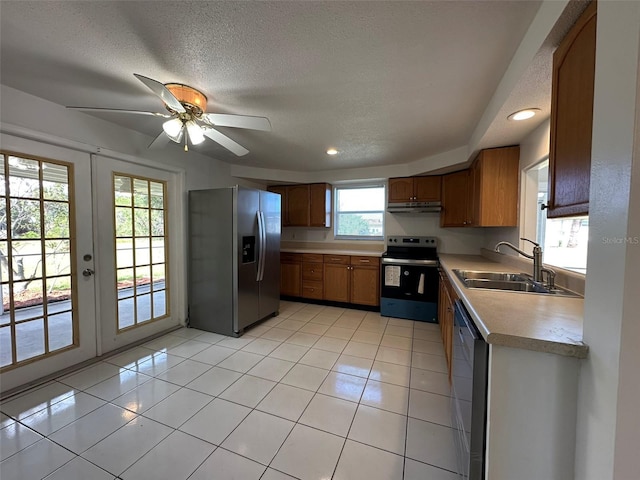 192 Garden Ave NW, Port Charlotte, FL 33952 - kitchen with light tile patterned floors, under cabinet range hood, stainless steel appliances, a sink, and light countertops