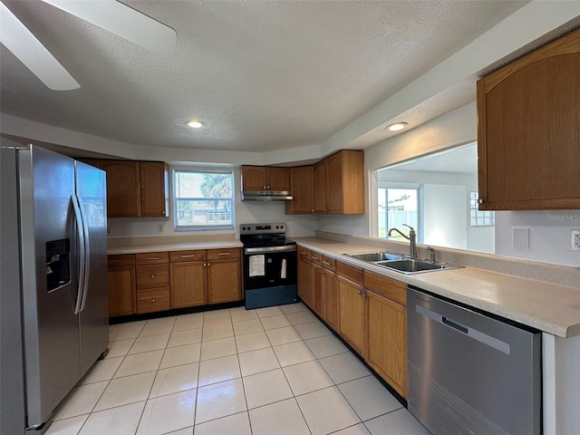 192 Garden Ave NW, Port Charlotte, FL 33952 - kitchen featuring brown cabinets, light countertops, appliances with stainless steel finishes, a sink, and under cabinet range hood