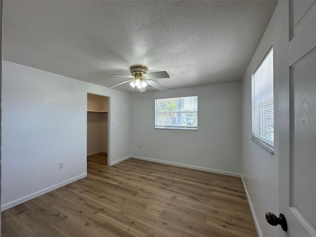 192 Garden Ave NW, Port Charlotte, FL 33952 - unfurnished bedroom with ceiling fan, a textured ceiling, wood finished floors, and baseboards