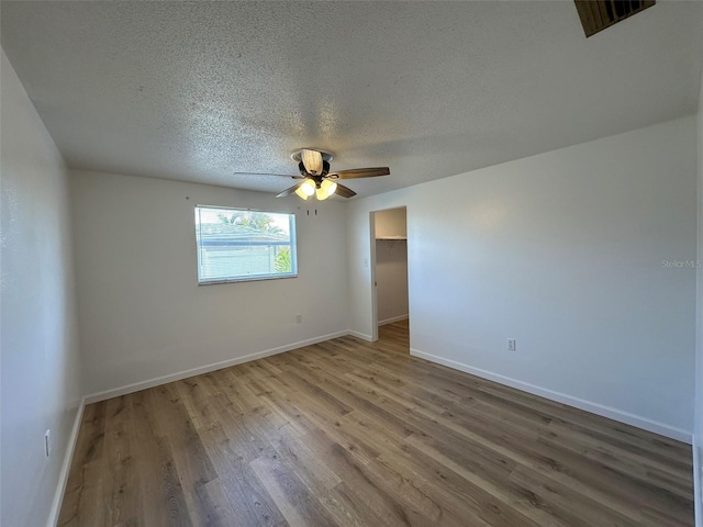 192 Garden Ave NW, Port Charlotte, FL 33952 - empty room featuring a ceiling fan, a textured ceiling, baseboards, and wood finished floors