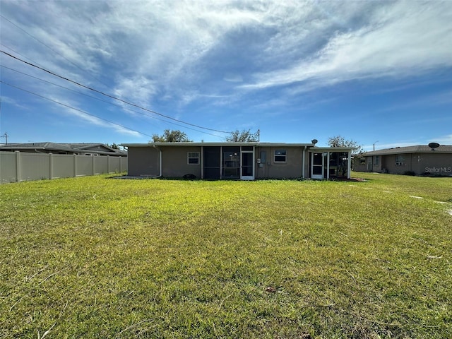 192 Garden Ave NW, Port Charlotte, FL 33952 - rear view of house featuring a sunroom, fence, and a yard