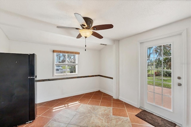 unfurnished room featuring baseboards, visible vents, a textured ceiling, and tile patterned floors