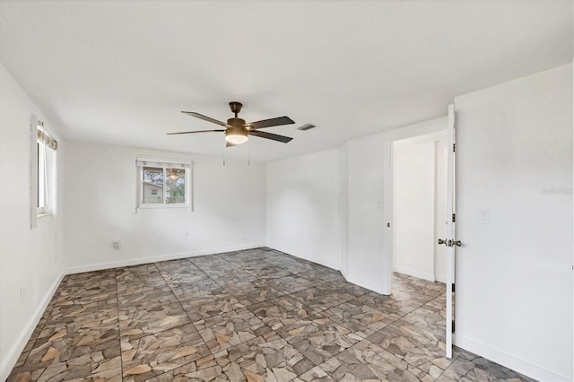 unfurnished room featuring ceiling fan, visible vents, and baseboards