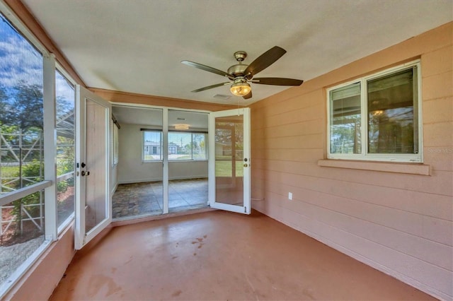 unfurnished sunroom featuring ceiling fan