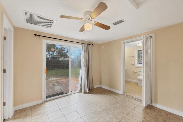 empty room featuring a wealth of natural light, visible vents, and baseboards