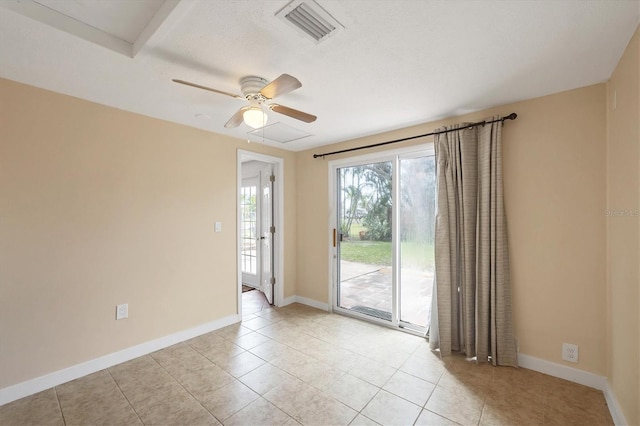 empty room featuring light tile patterned floors, baseboards, visible vents, and ceiling fan