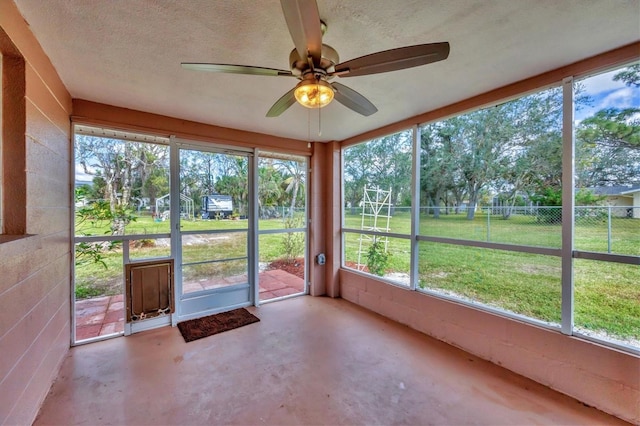 unfurnished sunroom with a ceiling fan