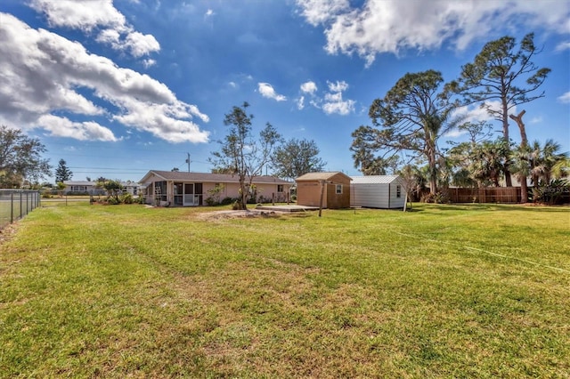 view of yard featuring a storage shed, an outbuilding, and a fenced backyard