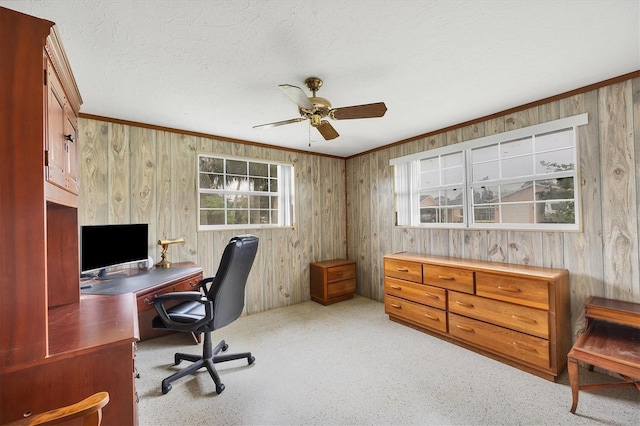 office area featuring a textured ceiling, light carpet, a ceiling fan, and crown molding