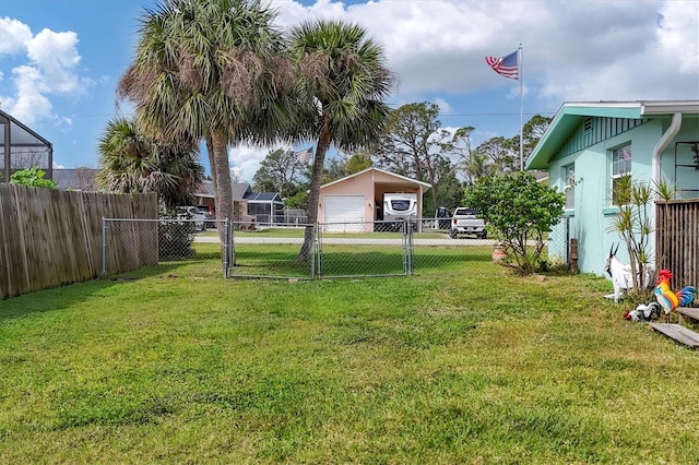 view of yard with a garage, an outdoor structure, fence, and a gate