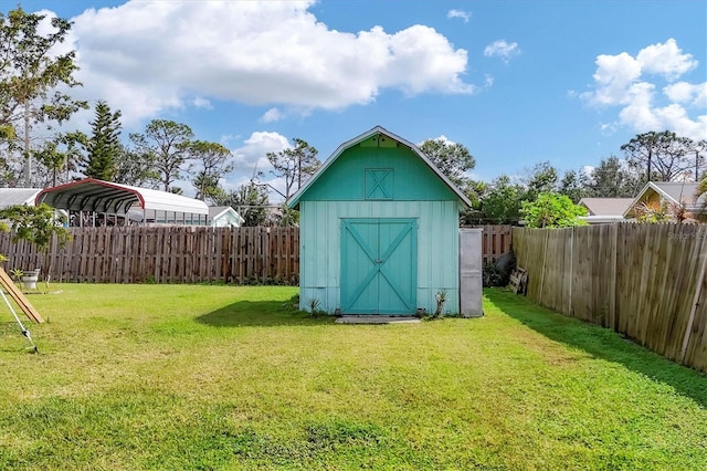 view of shed with a fenced backyard and a detached carport