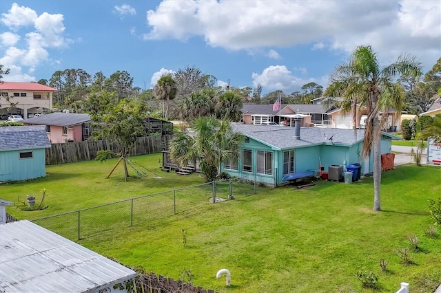 view of yard with cooling unit, a fenced backyard, an outdoor structure, and a shed