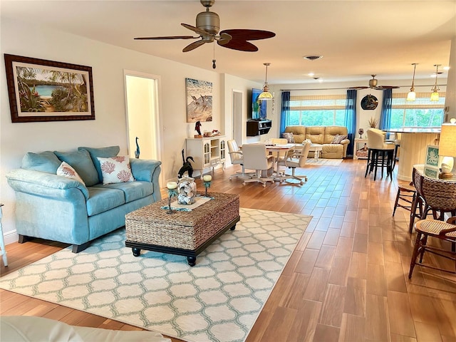 living room with ceiling fan and wood finished floors