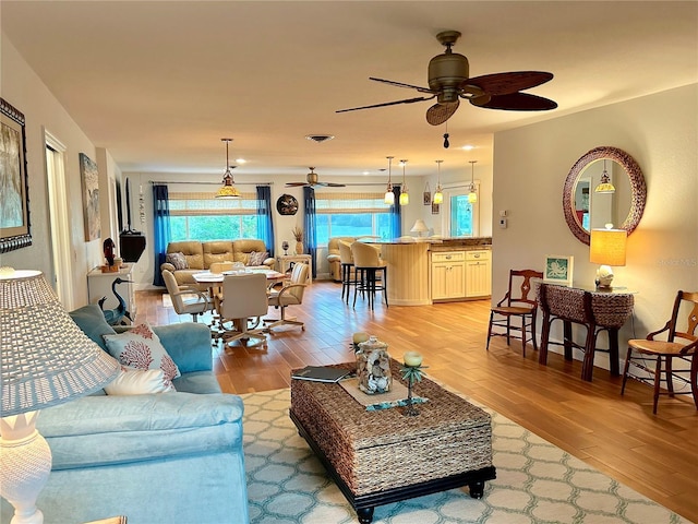 living room featuring light wood finished floors and a ceiling fan