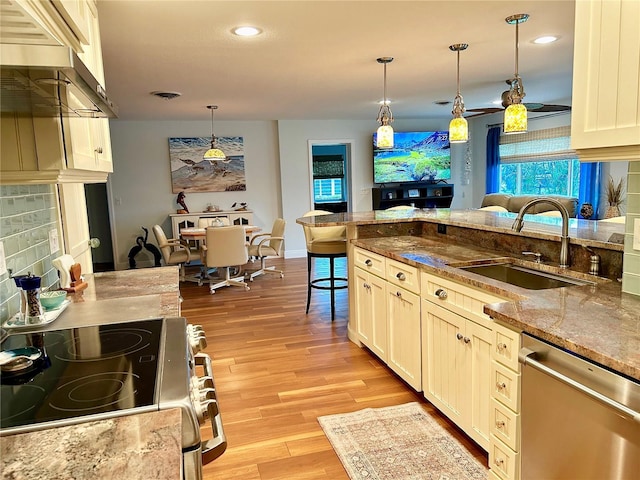 kitchen featuring light wood finished floors, visible vents, stainless steel appliances, pendant lighting, and a sink