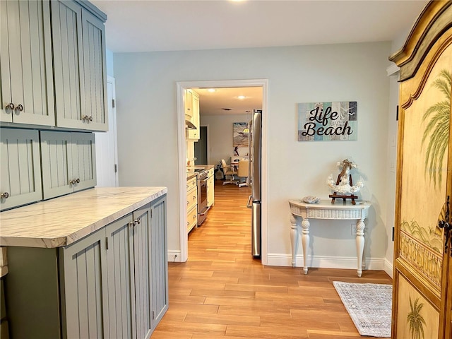 hall featuring light wood-style floors and baseboards