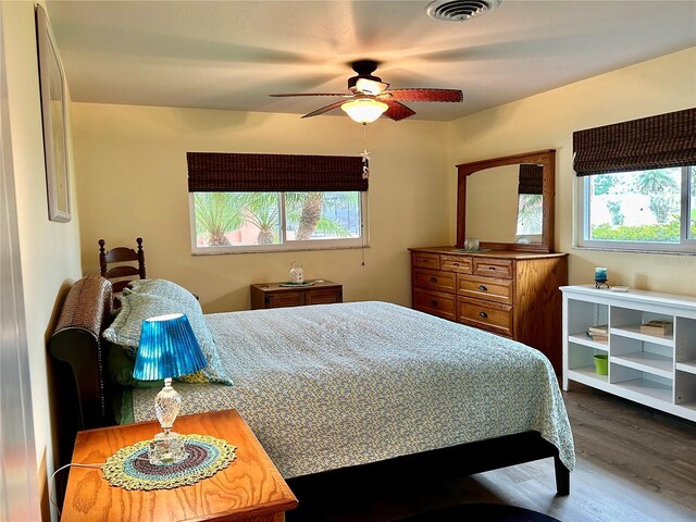 bedroom featuring visible vents, dark wood finished floors, and ceiling fan