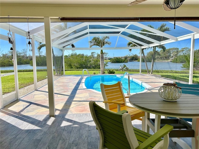 pool featuring a patio, a water view, and a lanai