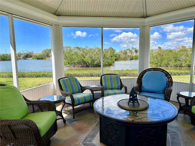 sunroom / solarium with a water view and lofted ceiling