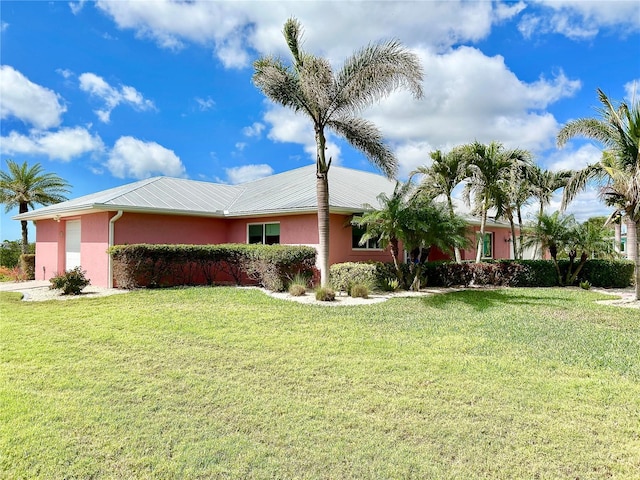 view of side of home featuring a lawn, an attached garage, and stucco siding