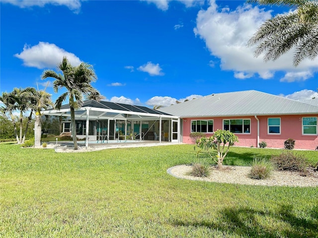 back of house featuring a lanai, metal roof, and a yard