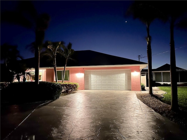 ranch-style house with concrete driveway, an attached garage, and stucco siding