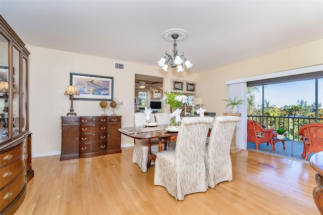 dining area with an inviting chandelier, baseboards, visible vents, and light wood-style floors