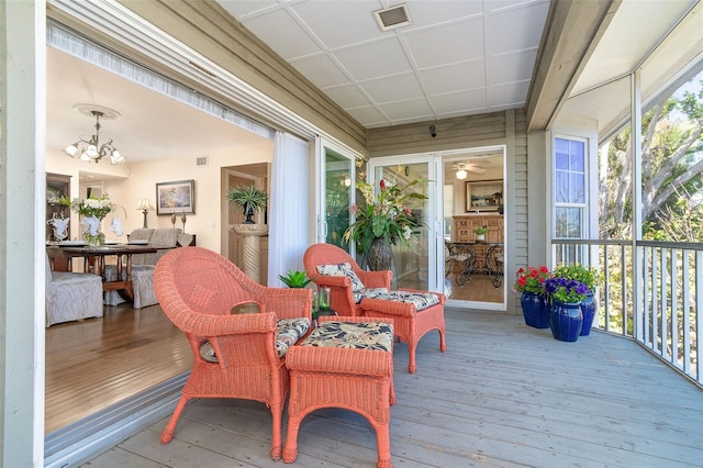 sunroom / solarium featuring visible vents and an inviting chandelier