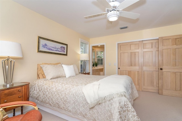 carpeted bedroom with a closet, visible vents, and a ceiling fan