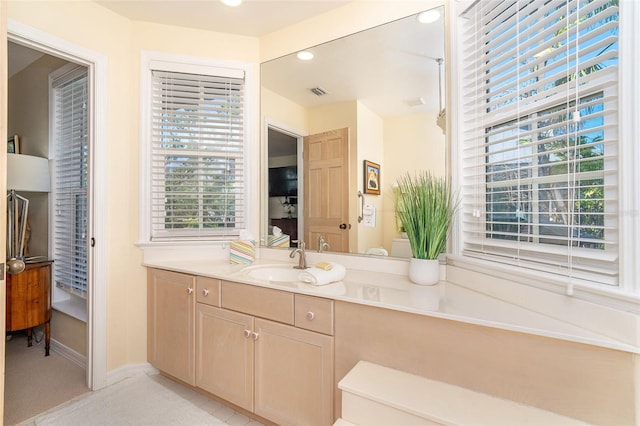 bathroom featuring visible vents, baseboards, vanity, and recessed lighting