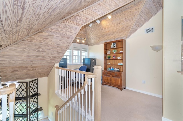 hallway with visible vents, baseboards, wooden ceiling, carpet, and an upstairs landing