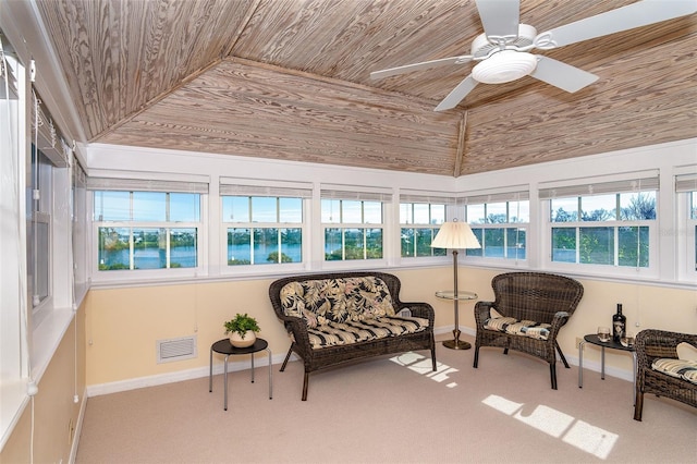 sunroom featuring a ceiling fan, wooden ceiling, visible vents, and plenty of natural light