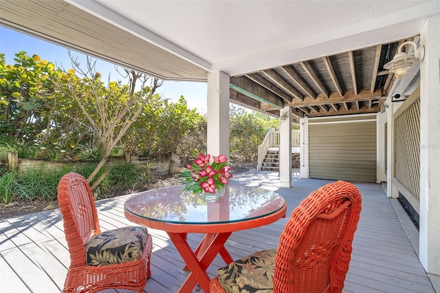 wooden terrace featuring outdoor dining area and stairs