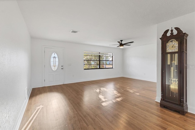 foyer entrance featuring visible vents, baseboards, a ceiling fan, and wood finished floors