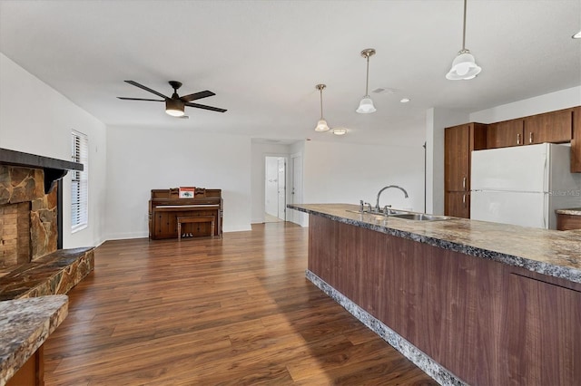 kitchen featuring dark wood-style floors, a ceiling fan, freestanding refrigerator, and a sink