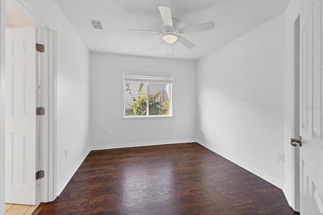 unfurnished room with baseboards, wood finished floors, visible vents, and ceiling fan