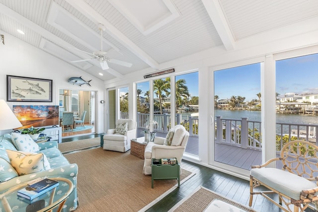 sunroom / solarium with a water view, lofted ceiling with beams, and a ceiling fan