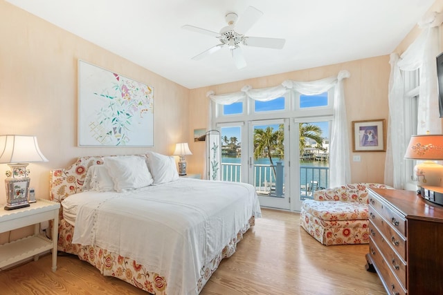 bedroom with access to exterior, light wood finished floors, and a ceiling fan