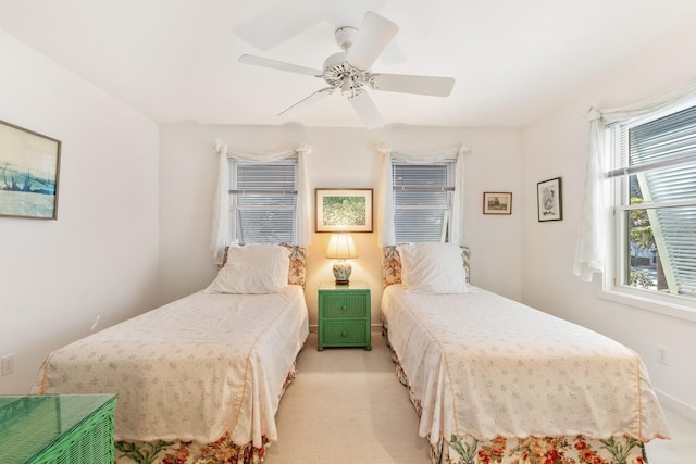 bedroom featuring baseboards, a ceiling fan, and light colored carpet