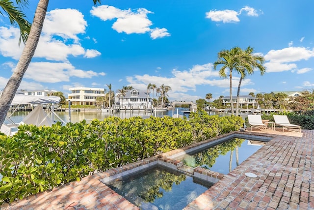 view of swimming pool featuring a boat dock and a water view